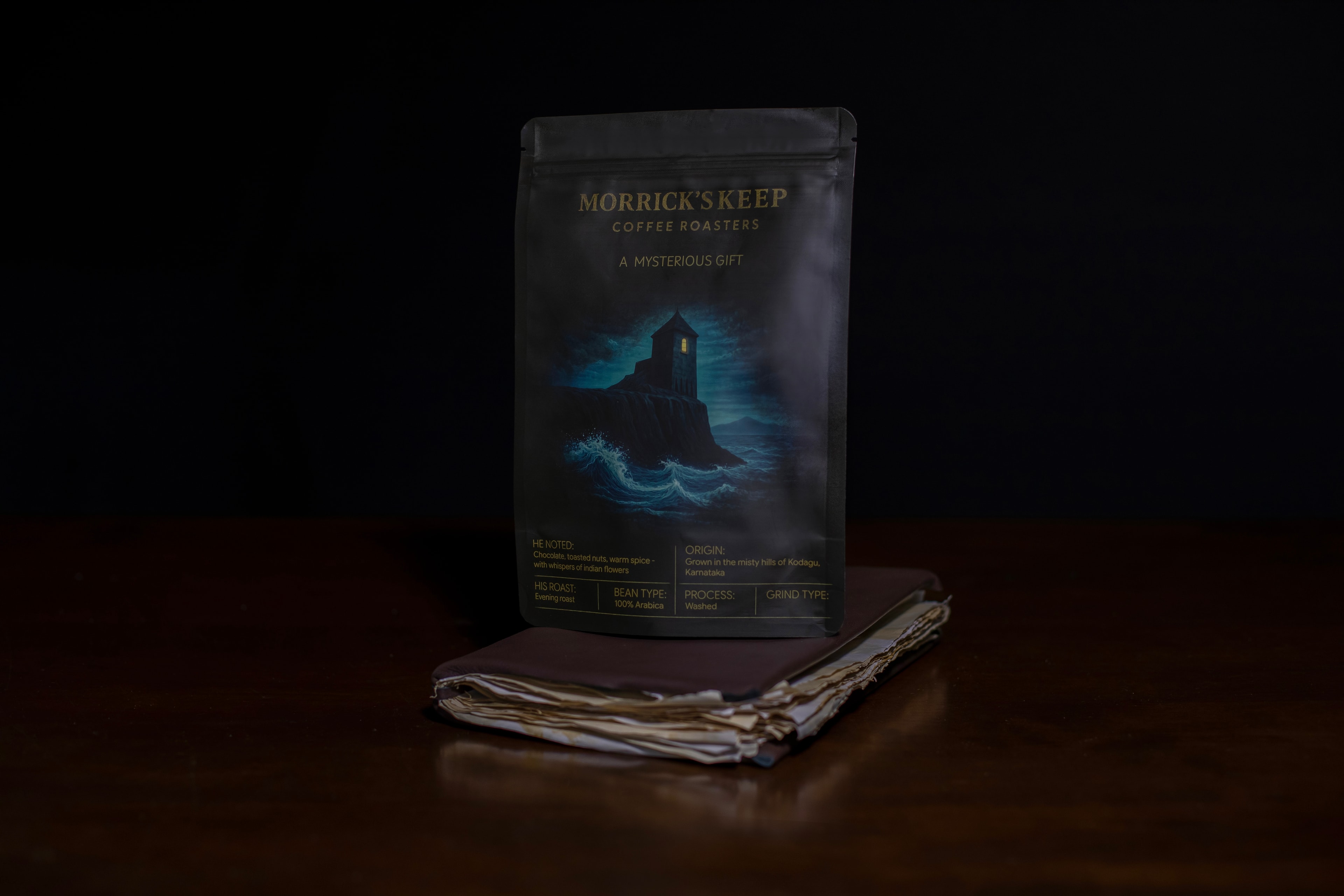 Morrick's Keep “A Mysterious Gift” coffee pouch — front, showing the lighthouse-keep above moonlit waves.